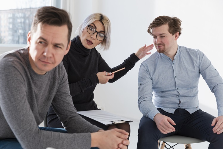 Kaksi miestä ja nainen istumassa